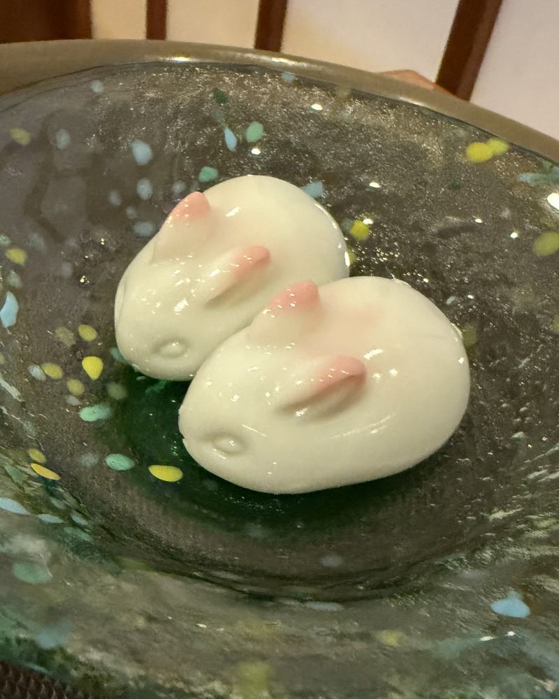 Two small white rabbit-shaped sweets on a glass plate