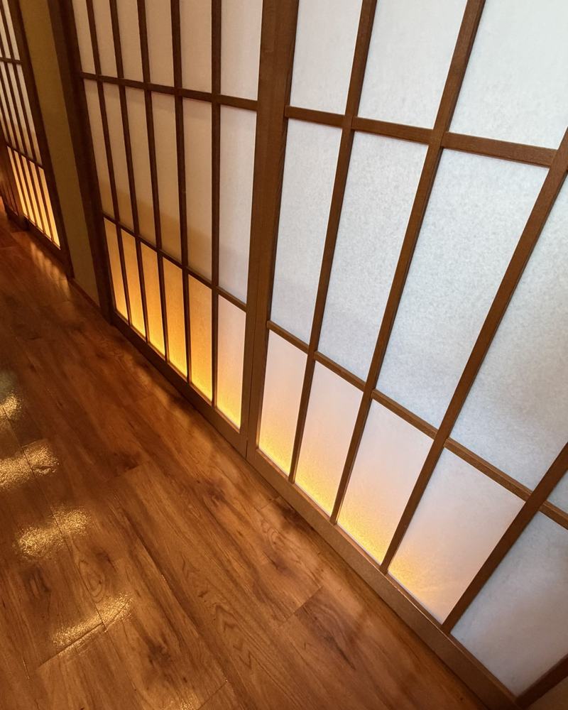 Glowing paper sliding doors along a wooden floor