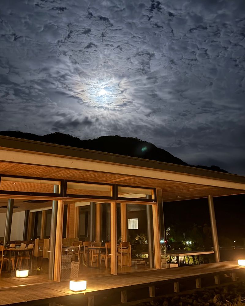 Moonlight over the mountains and a softly lit building at VISON at night